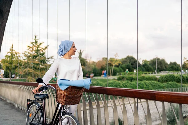 Mujer Musulmana Alegre Caminando Con Bicicleta Lado Pasarela Día Soleado Imagen de archivo
