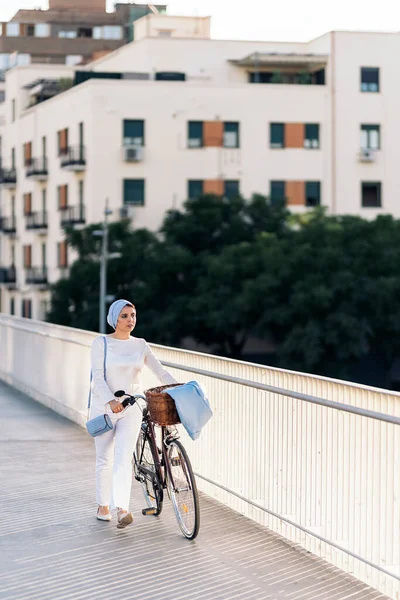 Wanita Muslim Yang Ceria Berjalan Dengan Sepedanya Sampingnya Jembatan Hari Stok Gambar Bebas Royalti