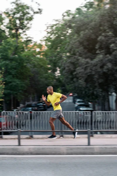 Vista Lateral Deportista Afroamericano Con Camiseta Amarilla Pantalones Cortos Corriendo — Foto de Stock