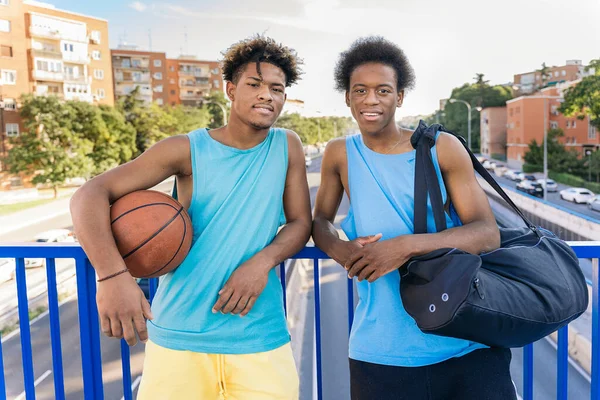 クールなアフリカ系アメリカ人男性保持バスケットボールボール笑顔とカメラを見て — ストック写真