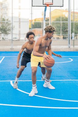 Güçlü ve sağlıklı Afrikalı arkadaşlar basketbol oynuyor ve eğleniyorlar..