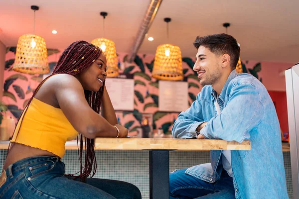 幸せなアフリカ系アメリカ人の女性がレストランで友人と座って食事を待っています — ストック写真