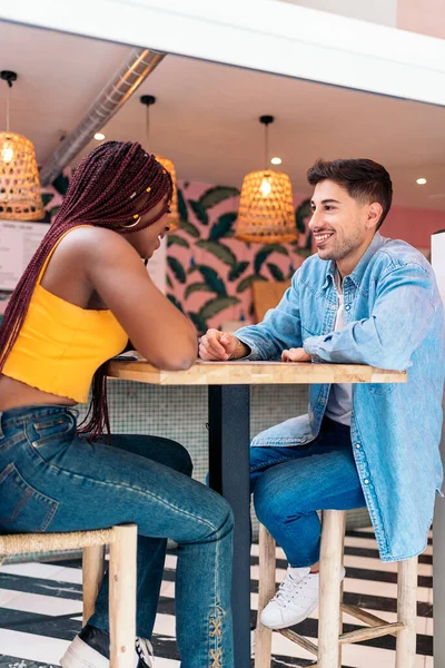 幸せなアフリカ系アメリカ人の女性がレストランで友人と座って食事を待っています — ストック写真
