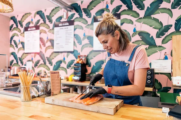 Trabalhadora Restaurante Usando Avental Luvas Látex Cortando Salmão Para Uma — Fotografia de Stock