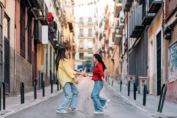 若いかなりアジア系の女性の友人がマドリードの街を歩いて楽しんでいます — ストック写真