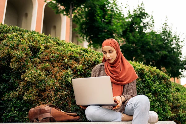 公園で彼女のコンピュータを使用して頭のスカーフを持つかなりイスラム教徒の女性 — ストック写真