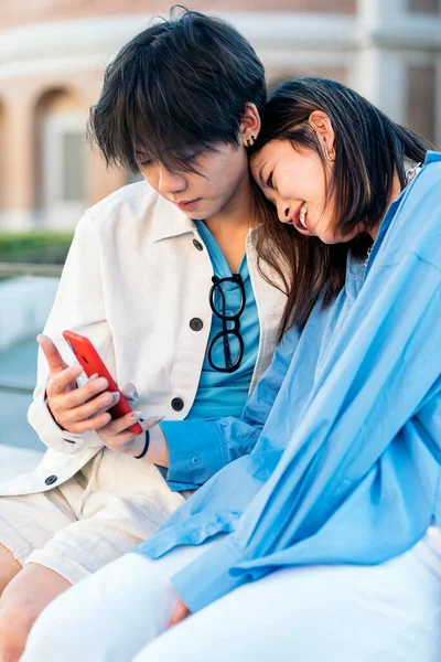 Happy Asian Couple Sitting Street Together Looking Smart Phone — Stock Photo, Image