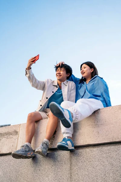 Feliz Jovem Asiático Casal Sentado Cidade Posando Tomando Selfie Com — Fotografia de Stock