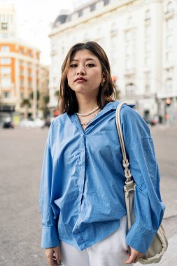 Madrid 'de poz veren ve kameraya bakan oldukça moda Asyalı bir kadın..