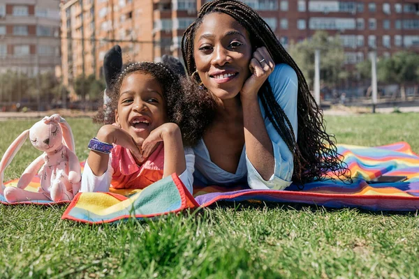 Cute Afro Girl Lying Grass Colorful Picnic Blanket Her Mom — ストック写真