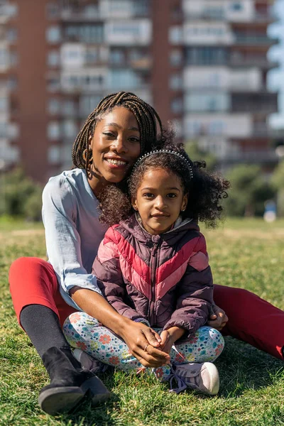 Linda Afro Chica Sentada Hierba Con Mamá Sonriendo Mirando Cámara — Foto de Stock