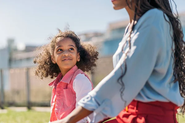 愛らしいです若いです黒女の子とともにアフロ髪遊びます公園で彼女の母親と楽しいです — ストック写真