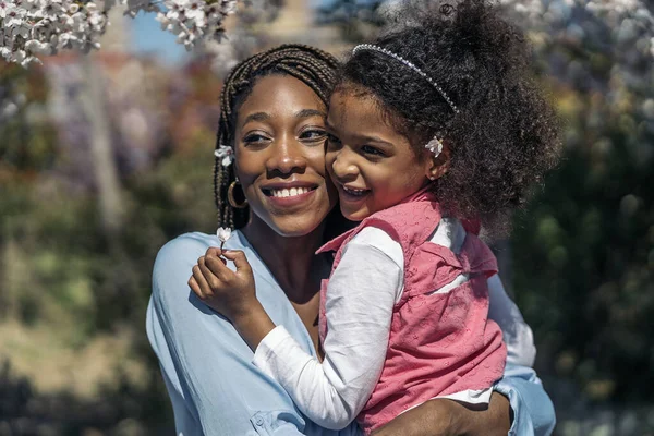 Mujer Negra Con Trenzas Abrazando Hija Pequeña Parque Durante Día — Foto de Stock