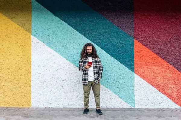Hombre Hipster Confianza Pie Contra Pared Colores Ciudad Utilizando Teléfono —  Fotos de Stock
