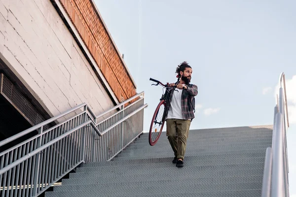 Cool Hipster Hombre Llevando Bicicleta Mientras Camina Por Las Escaleras —  Fotos de Stock