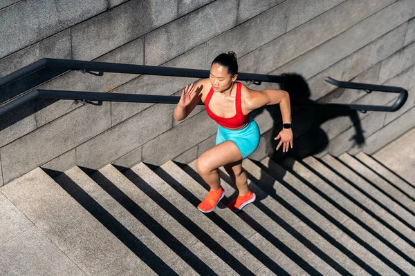 晴れた日に市内でスポーツウェアが動作して強力なアジアの女性 彼女は階段登りだ — ストック写真