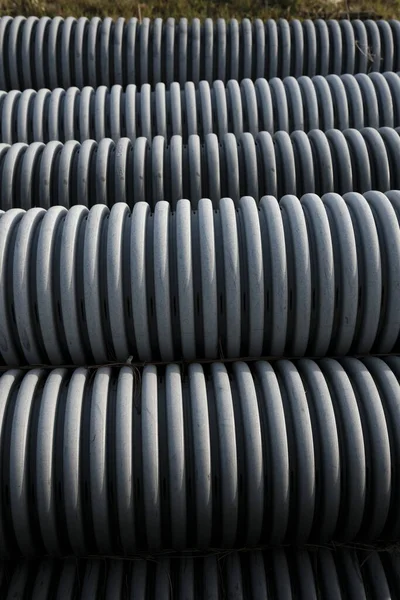 corrugated grey plastic piping stacked