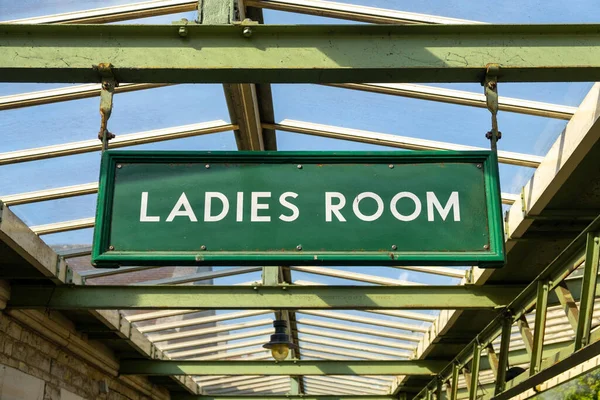 ladies room green sign on a train station
