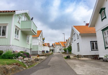 Ockero, İsveç - 10 Haziran 2021: Renkli evleri olan tipik İsveç köyünün karşı tarafındaki Chanel 'de bir rıhtım