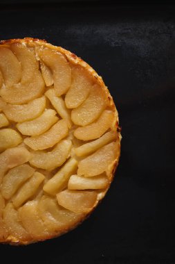 Elmalı tart, dilimlenmiş elma ve üzerine yapışkan sos. Kopyalama alanı olan koyu siyah bir arkaplan ayarla