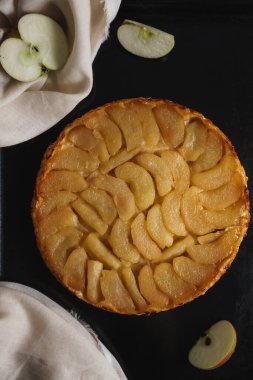 Elmalı tart, dilimlenmiş elma ve üzerine yapışkan sos. Kopyalama alanı olan koyu siyah bir arkaplan ayarla