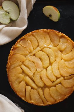 Elmalı tart, dilimlenmiş elma ve üzerine yapışkan sos. Kopyalama alanı olan koyu siyah bir arkaplan ayarla