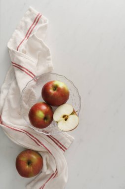 Mutfak yüzeyine karşı bir kasede taze elma. Fotokopi alanı olan hafif ve havadar yiyecek resmi.