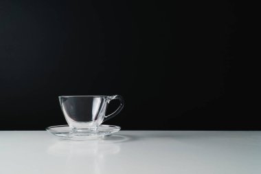 Siyah arka planda tek cam kahve fincanı. Kopyalama alanı olan siyah ve beyaz tek renkli resim