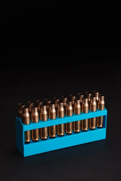 Amber Gold Empty Bullet Cases Blue Holder Aginst Dark Black — Stock Photo, Image