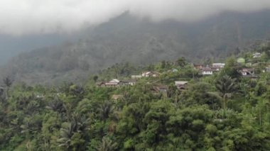 Drone video of the natural beauty of the countryside, looks at the houses of residents in the countryside, with beautiful mountain views.