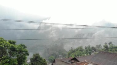 Drone video of the natural beauty of the countryside, looks at the houses of residents in the countryside, with beautiful mountain views.