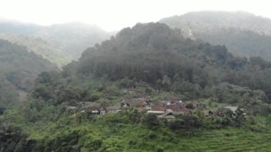 Drone video of the natural beauty of the countryside, looks at the houses of residents in the countryside, with beautiful mountain views.