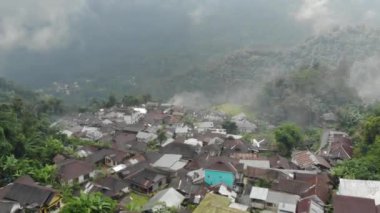 Drone video of the natural beauty of the countryside, looks at the houses of residents in the countryside, with beautiful mountain views.