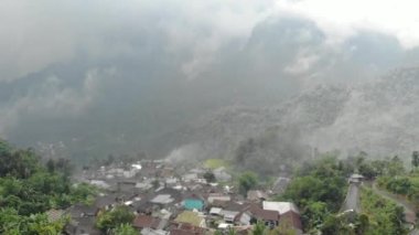 Drone video of the natural beauty of the countryside, looks at the houses of residents in the countryside, with beautiful mountain views.