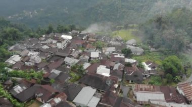 Drone video of the natural beauty of the countryside, looks at the houses of residents in the countryside, with beautiful mountain views.