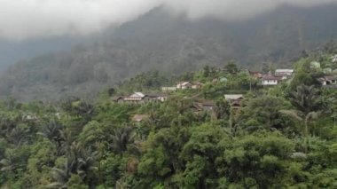 Drone video of the natural beauty of the countryside, looks at the houses of residents in the countryside, with beautiful mountain views.