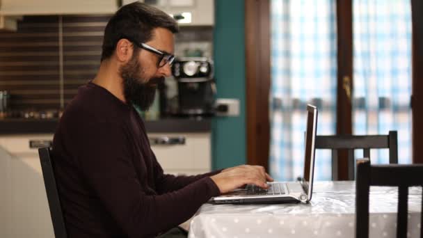 Человек Бородой Сидит Работает Ноутбуком Дома — стоковое видео