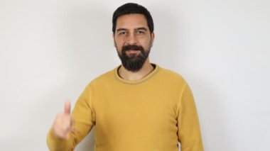 Sıradan kıyafetler giyen sakallı bir adam eliyle telefon işareti yapıyor. Telefon görüşmesi kavramı.