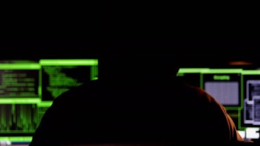 Kapüşonlu bilgisayar korsanı verileri inceliyor. Para ve bilgi çalmak için korumalı sistemleri girin. Siber terör kavramı.