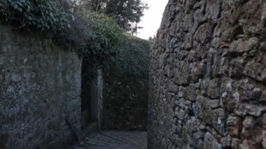 POV 'ta çekim yapmak, İtalya' nın Toskana kentindeki tarihi Volterra merkezinin antik duvarları arasında yürümek..