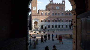 Siena, Toskana, İtalya - 12 Şubat 2022: POV 'ta çekim, Siena' nın tarihi merkezinde Piazza del Campo 'da bir atari salonunun altında yürümek.