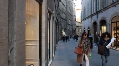 Siena, Toskana, İtalya - 12 Şubat 2022: Siena 'nın tarihi merkezindeki POV caddelerinde dükkanlar arasında turistlerin yürüdüğü çatışmalar.