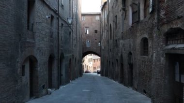 Siena, Toskana, İtalya - 12 Şubat 2022: POV saldırısı, Siena 'nın tarihi merkezinde güzel bir ortaçağ geçidinde yürüyor.