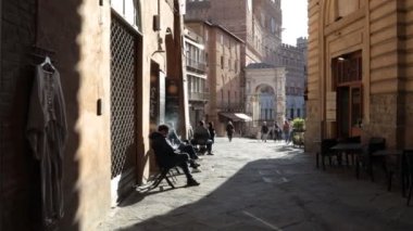 Siena, Toskana, İtalya - 12 Şubat 2022: POV 'ta vurulma, şehrin tarihi merkezinde Piazza del Campo' ya giden bir ara sokakta yürüme.