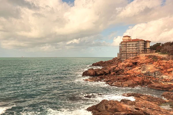 Boccale şatosu, yenileme için iskelesi, gözetleme kulesi olan ortaçağ malikanesi. Kale İtalya 'nın Toskana kentindeki Livorno uçurumunun üzerinde duruyor. HDR fotoğrafı.