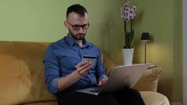 Mężczyzna Brodą Siedzi Kanapie Pomocą Laptopa Karty Kredytowej Dokonać Płatności — Wideo stockowe