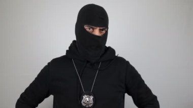 Özel kuvvetler polisi kar maskeli ve elleri kalçasında kameraya bakıyor..