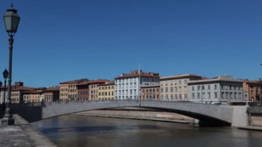 Pisa, Toskana, İtalya - 5 Nisan 2022: Arno nehri üzerindeki ünlü Ponte Di Mezzo köprüsü ile Pisa şehir manzarasının zaman aşımı.