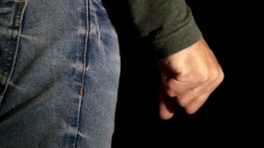 Kızgın Adam siyah arka planda yumruğunu sıkıyor. Bir kişi deliriyor ve bir yumrukta parmaklarını sıkıyor. Kapat.