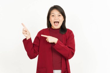 Beyaz arka planda kırmızı tişörtlü güzel Asyalı bir kadını işaret ediyor.